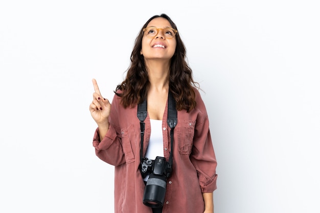 Mulher jovem fotógrafo sobre branco isolado apontando para cima e surpreso
