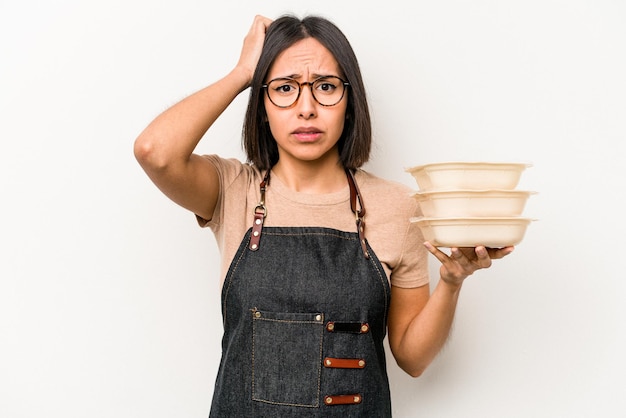 Mulher jovem garçonete caucasiana segurando tupperware isolado no fundo branco, chocada, ela se lembrou de uma reunião importante