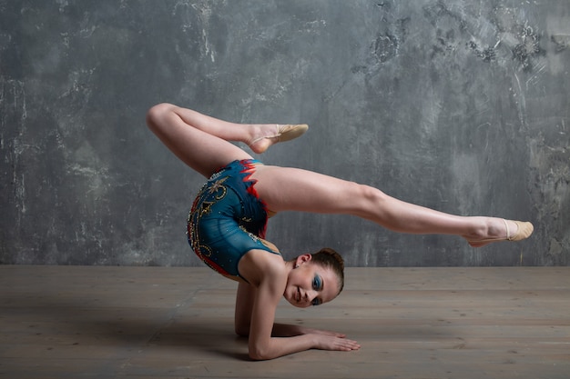 Mulher jovem ginasta profissional dançar ginástica rítmica no estúdio.