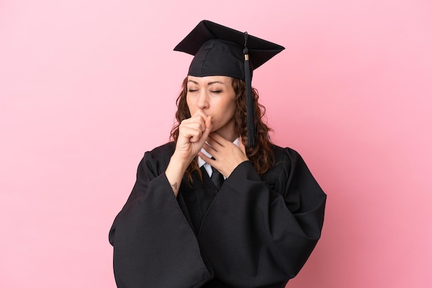 Mulher jovem graduada da universidade isolada em fundo rosa está sofrendo com tosse e se sentindo mal