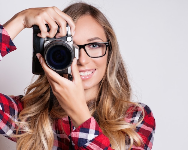 Mulher jovem hippie com câmera digital sorrindo