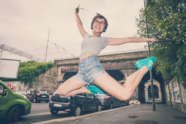 Mulher jovem hippie ouvindo música pulando