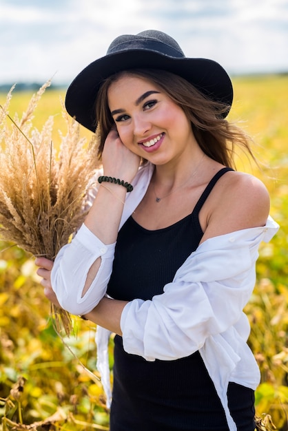 Mulher jovem incrivelmente bonita posando em um campo rural no verão. estilo de vida