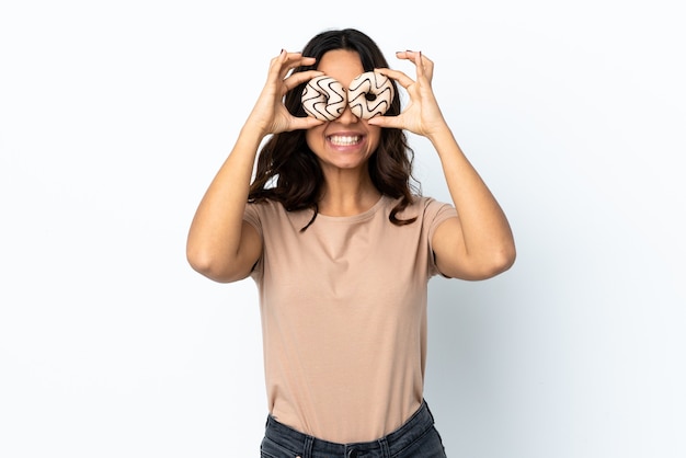 Mulher jovem isolada segurando rosquinhas nos olhos