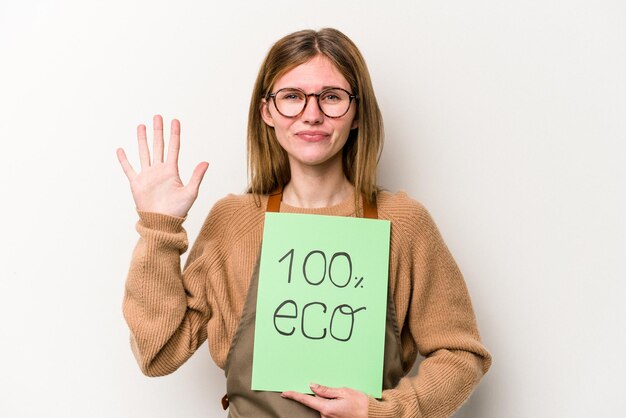 Mulher jovem jardineiro segurando um cartaz 100% eco isolado no fundo branco sorrindo alegre mostrando o número cinco com os dedos.