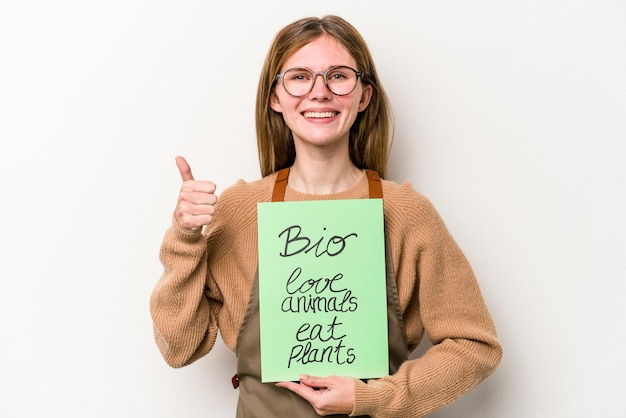 Mulher jovem jardineiro segurando um cartaz bio isolado no fundo branco sorrindo e levantando o polegar