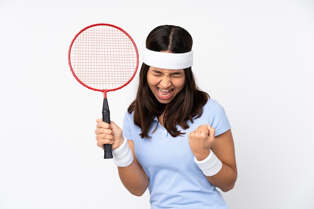 Mulher jovem jogador de badminton sobre fundo branco isolado comemorando vitória