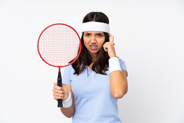 Mulher jovem jogador de badminton sobre fundo branco isolado frustrada e cobrindo as orelhas