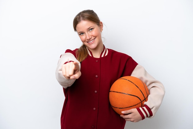 Mulher jovem jogador de basquete isolada no fundo branco, apontando para a frente com expressão feliz