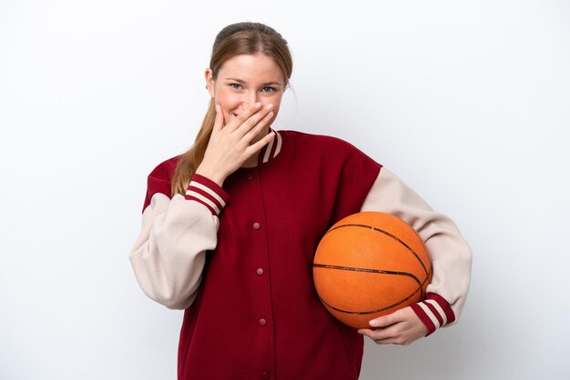 Mulher jovem jogador de basquete isolada no fundo branco feliz e sorridente cobrindo a boca com a mão