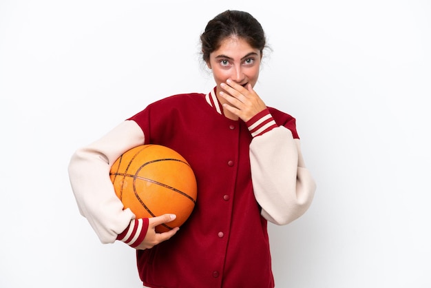 Mulher jovem jogador de basquete isolada no fundo branco feliz e sorridente cobrindo a boca com a mão