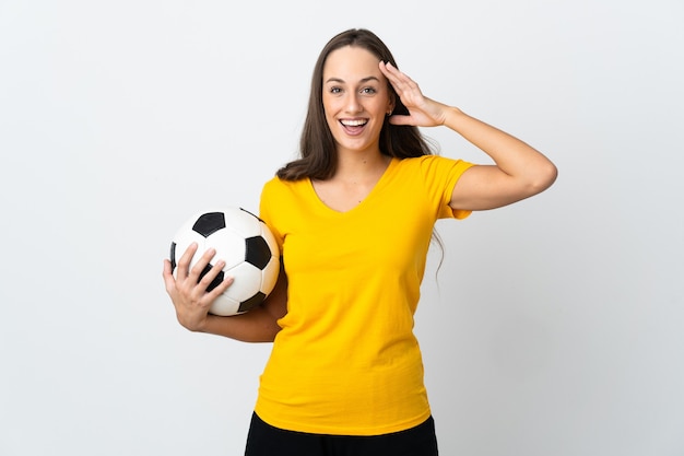 Mulher jovem jogador de futebol em uma parede branca isolada com expressão de surpresa