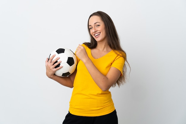 Mulher jovem jogador de futebol em uma parede branca isolada comemorando uma vitória