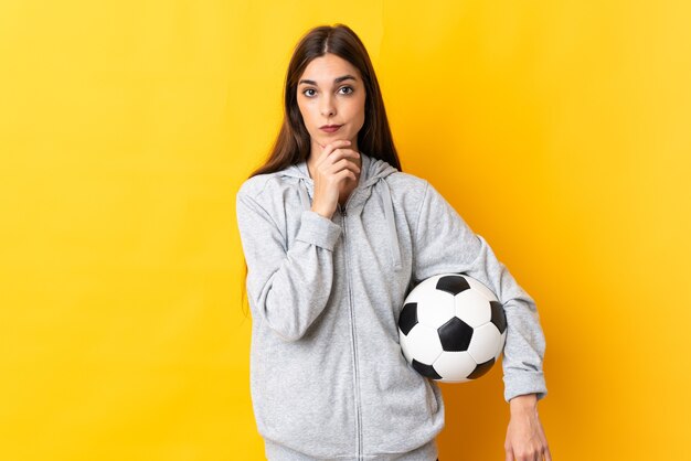 Mulher jovem jogador de futebol isolada em pensamento amarelo