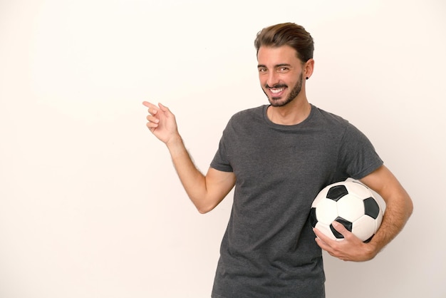 Mulher jovem jogador de futebol isolada no fundo branco, apontando o dedo para o lado