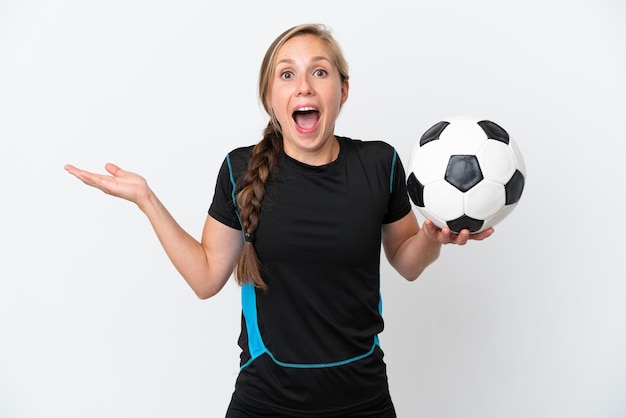 Mulher jovem jogador de futebol isolada no fundo branco com expressão facial chocada