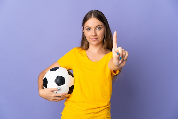 Mulher jovem jogador de futebol lituano isolada na parede roxa, mostrando e levantando um dedo