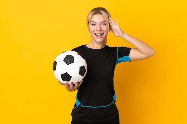 Mulher jovem jogador de futebol russo isolada em amarelo com expressão de surpresa