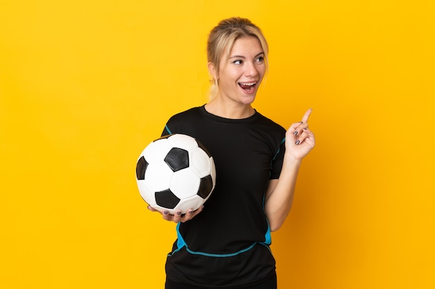 Mulher jovem jogador de futebol russo isolada na parede amarela com a intenção de perceber a solução enquanto levanta um dedo