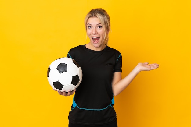 Mulher jovem jogador de futebol russo isolada na parede amarela com expressão facial chocada
