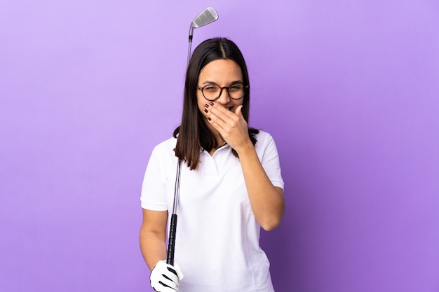 Mulher jovem jogador de golfe sobre parede colorida isolada feliz e sorridente cobrindo a boca com a mão