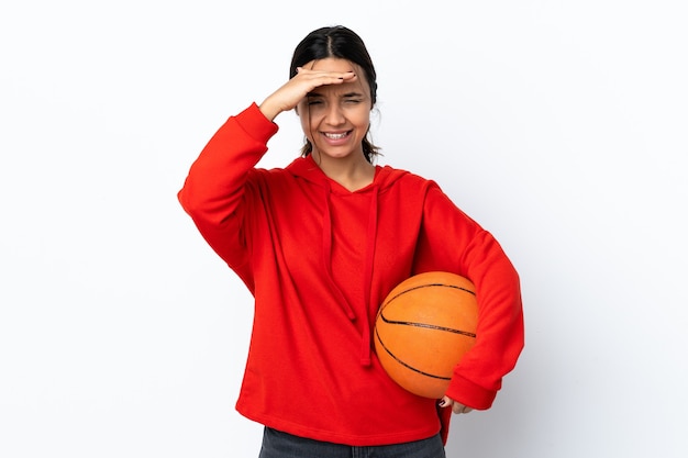 Mulher jovem jogando basquete sobre um fundo branco isolado olhando para longe com a mão para olhar algo