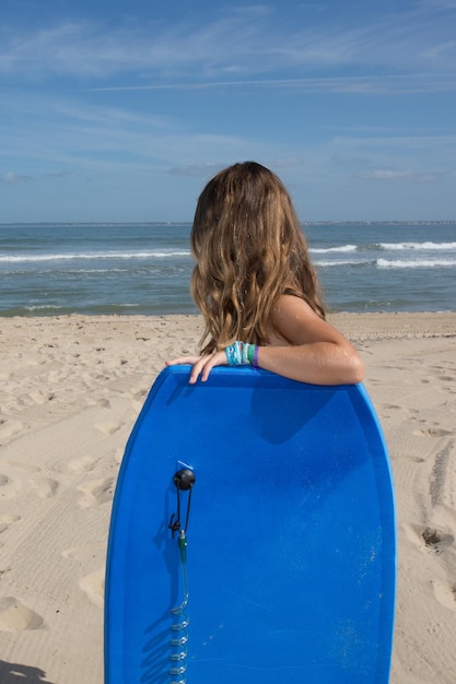 mulher jovem jogando body board na praia de verão