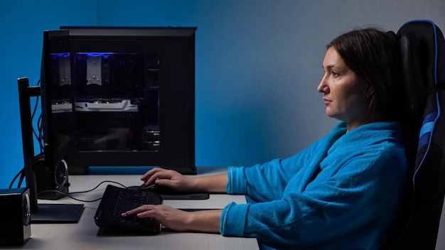 Mulher jovem jogando computador sentada em uma cadeira confortável