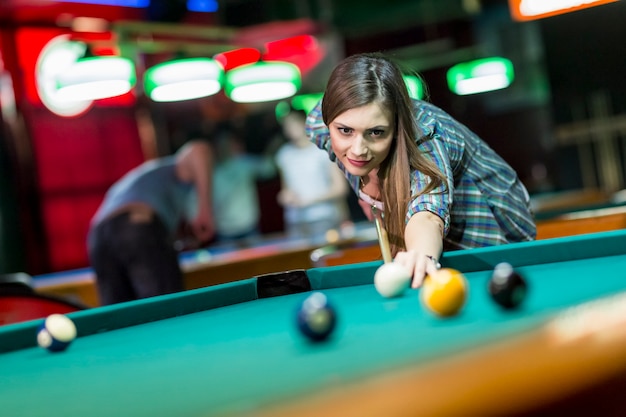 Mulher jovem, jogando pool