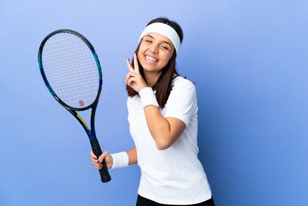 Mulher jovem, jogando tênis, parede