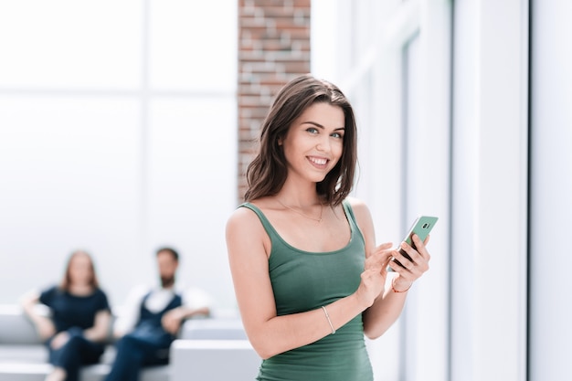 Mulher jovem lendo SMS em seu smartphone