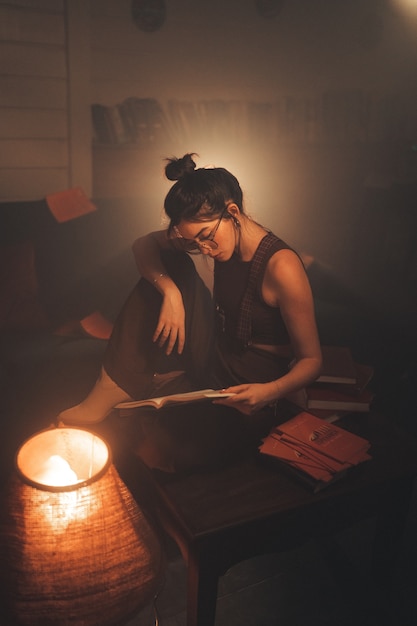 Foto mulher jovem, lendo um livro, casa