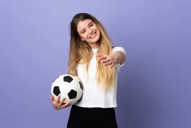 Mulher jovem loira jogador de futebol em roxo com expressão facial surpresa