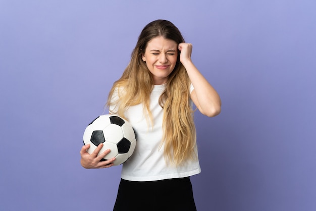 Mulher jovem loira jogador de futebol isolada na parede roxa frustrada e cobrindo as orelhas