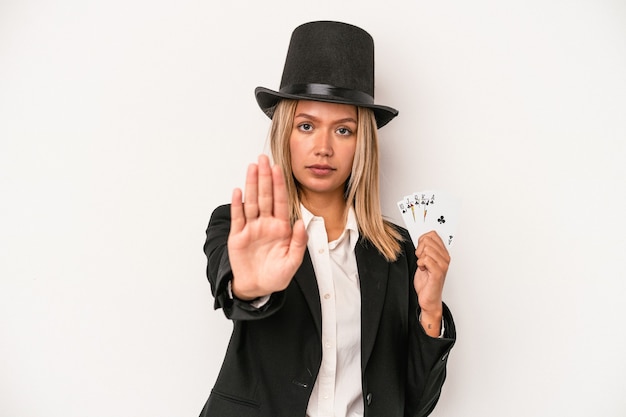 Mulher jovem mago caucasiano segurando o cartão mágico isolado no fundo branco, de pé com a mão estendida, mostrando o sinal de stop, impedindo-o.