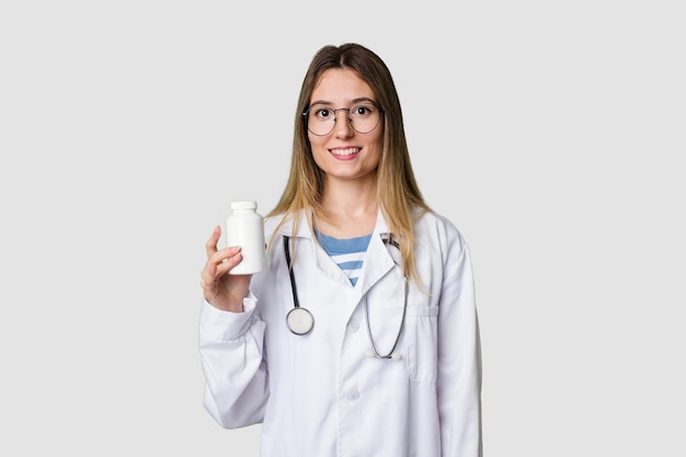 Mulher jovem médico segurando comprimidos isolados