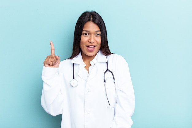 Mulher jovem médico venezuelana isolada sobre fundo azul, tendo uma ideia, o conceito de inspiração.