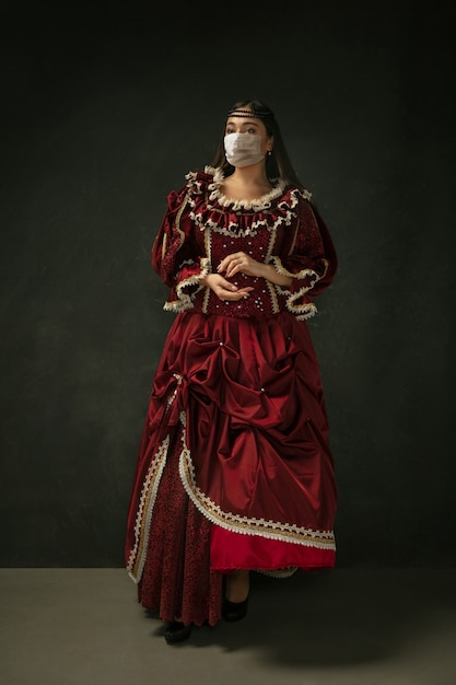Mulher jovem medieval como uma duquesa usando máscara protetora contra a propagação do coronavírus