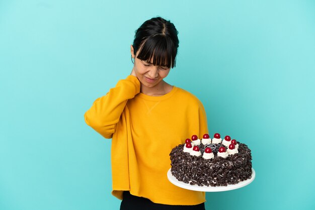 Mulher jovem mestiça segurando um bolo de aniversário com dor no pescoço