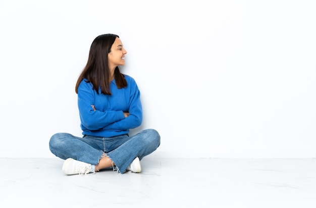 Mulher jovem mestiça sentada no chão