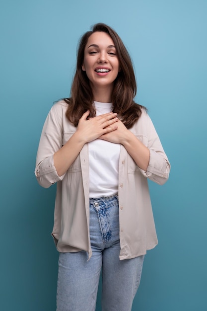 Mulher jovem morena caucasiana sorridente em jeans e camisa