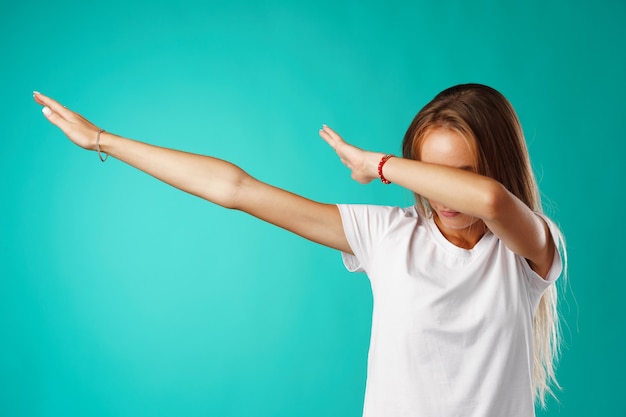 Mulher jovem mostrando um movimento de dança de salpico contra um fundo de hortelã