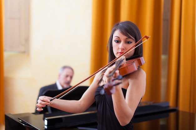 Mulher jovem músico tocando seu violino