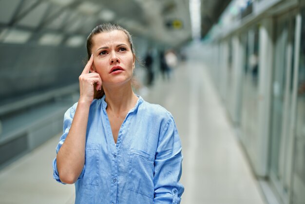 Mulher jovem na estação de metrô.