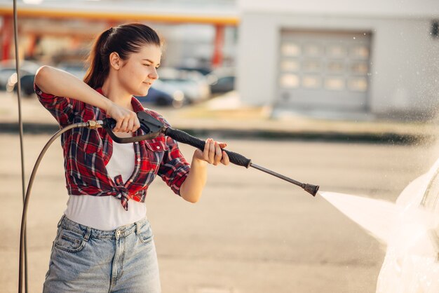 Mulher jovem na lavagem de carros self-service