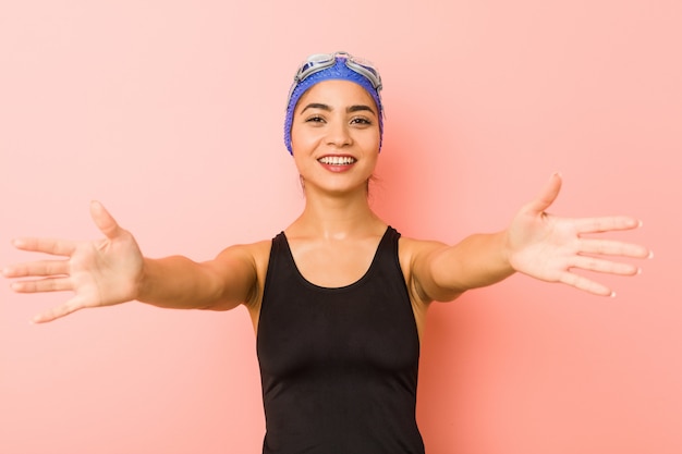 Foto mulher jovem nadador árabe isolada se sente confiante, dando um abraço para a câmera.