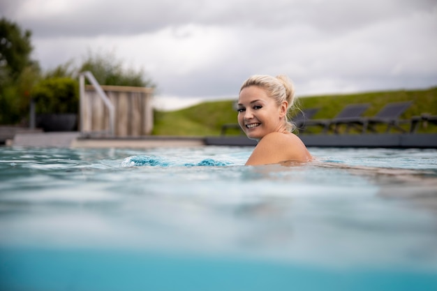 Mulher jovem nadando em uma piscina em um hotel spa