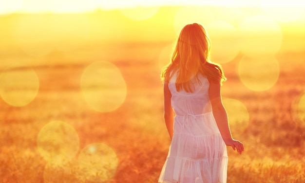 Mulher jovem no campo sob a luz do sol