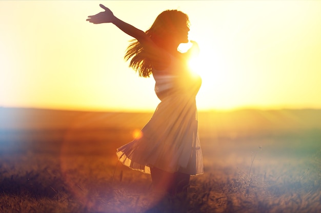 Mulher jovem no campo sob a luz do sol