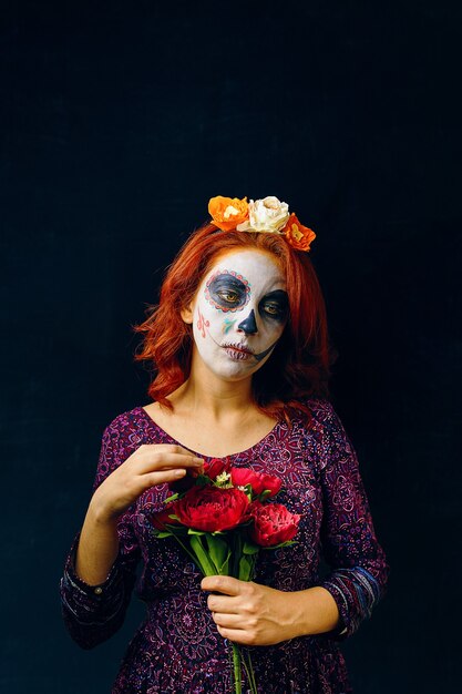 Mulher jovem no dia dos mortos máscara de halloween máscara facial arte maquiagem sobre fundo preto